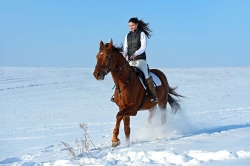 © kyslynskyy - Fotolia.com Reiterin Winterlandschaft